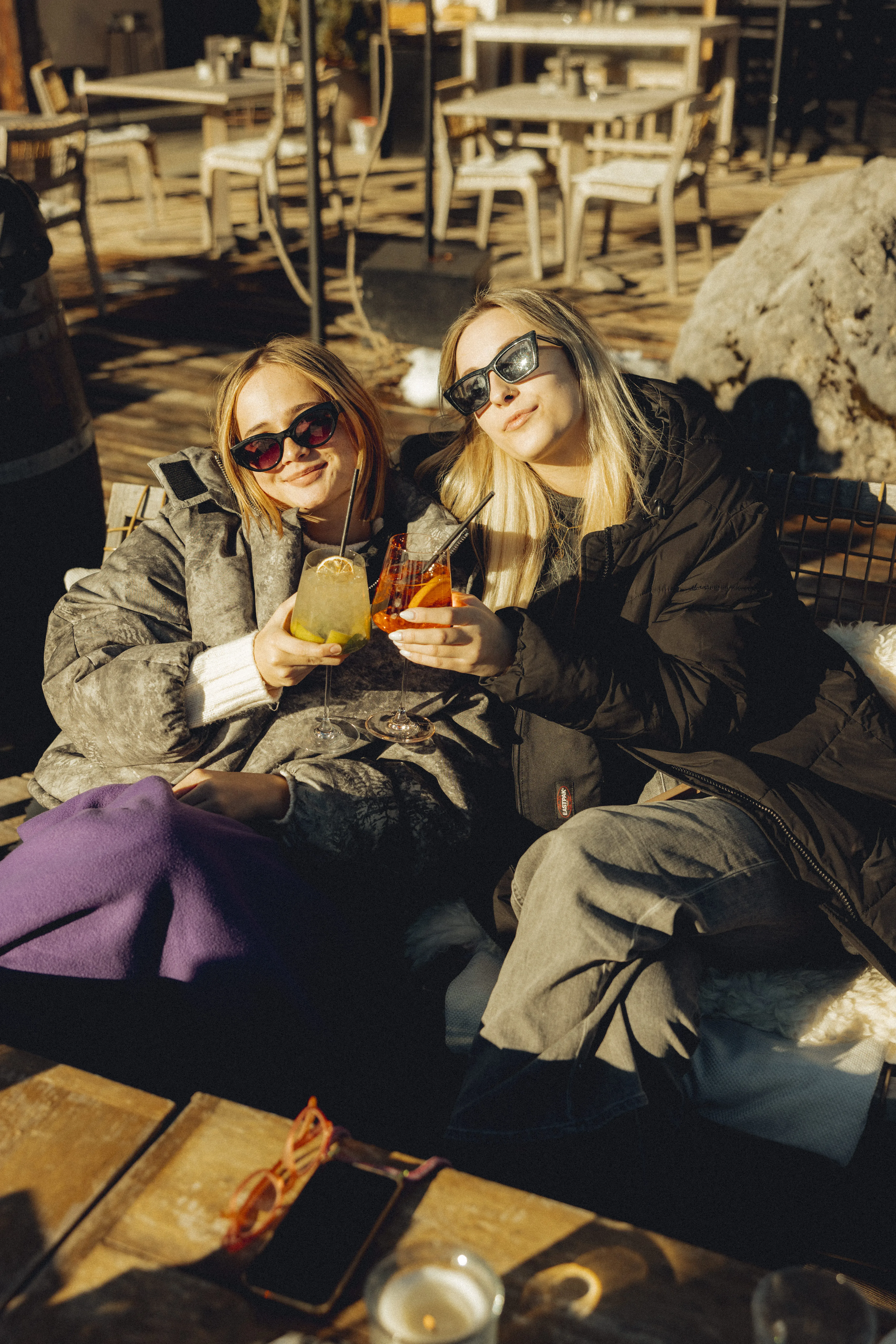 Vrouwen genieten van drankjes in de winterzon